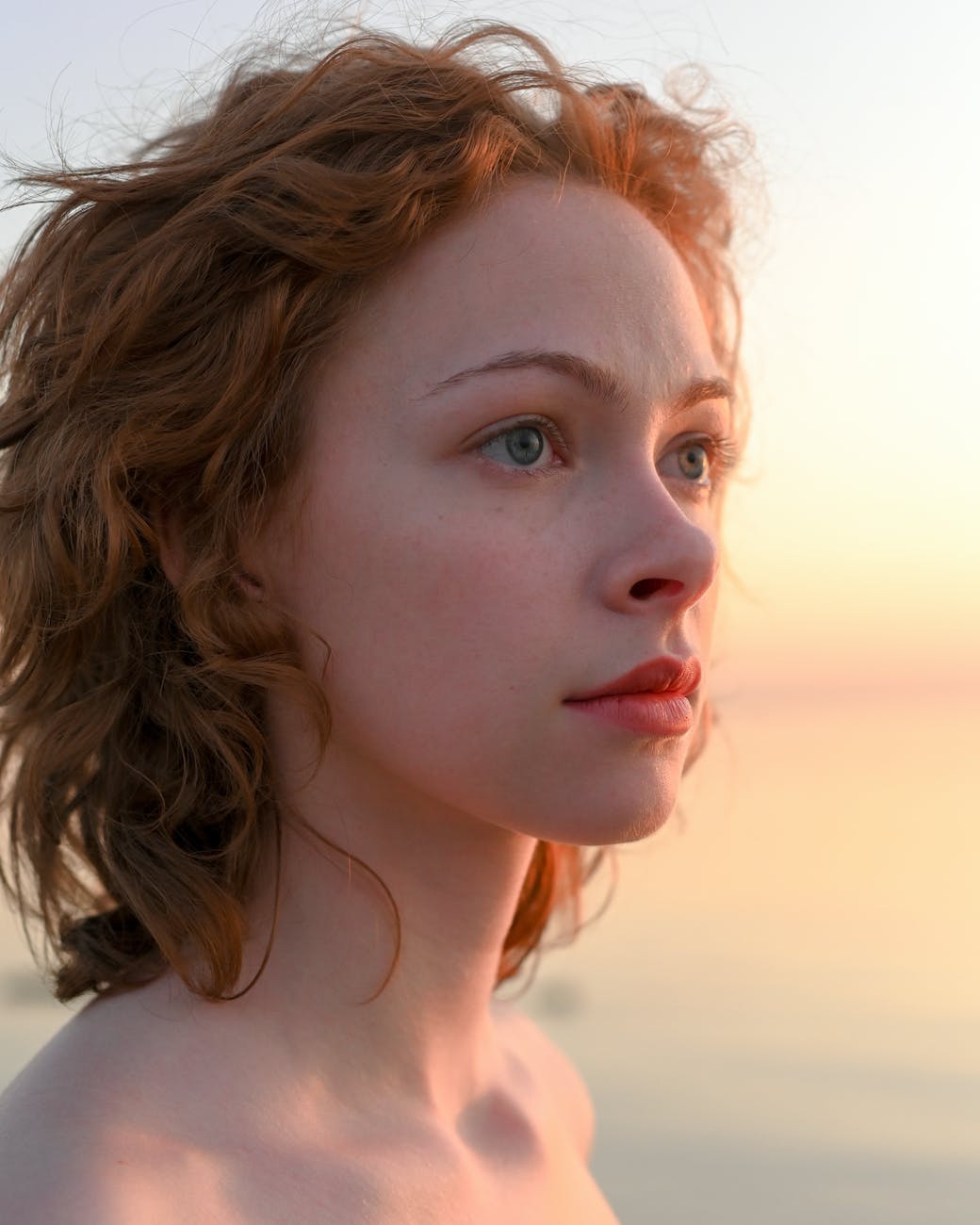 interesting face of attractive redhead woman at sunset